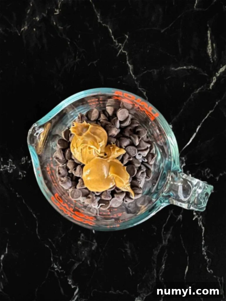 Salty Sweet Peanut Butter Pretzel Bars 7 Peanut butter and chocolate chips in a small glass measuring cup for melting.