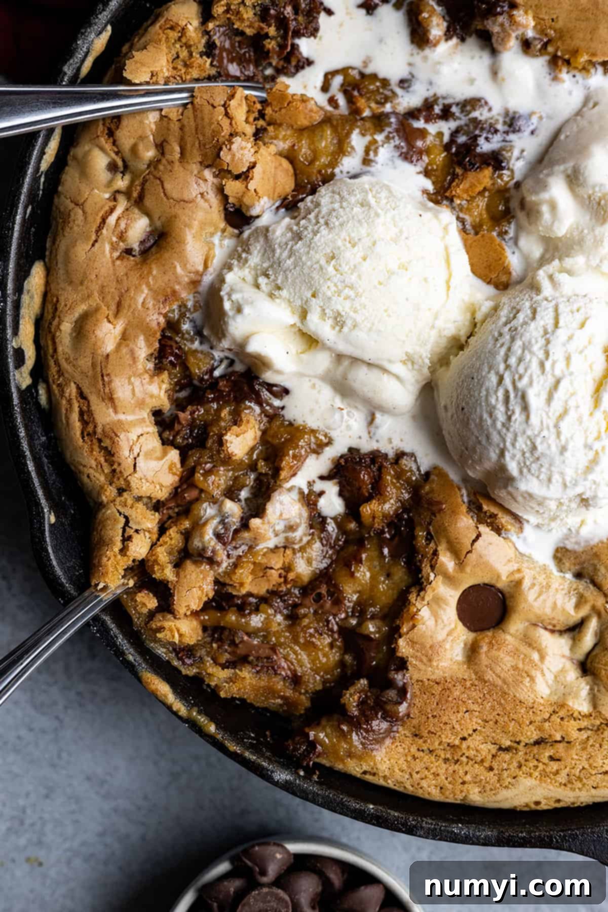 A skillet filled with a gooey cookie and ice cream.