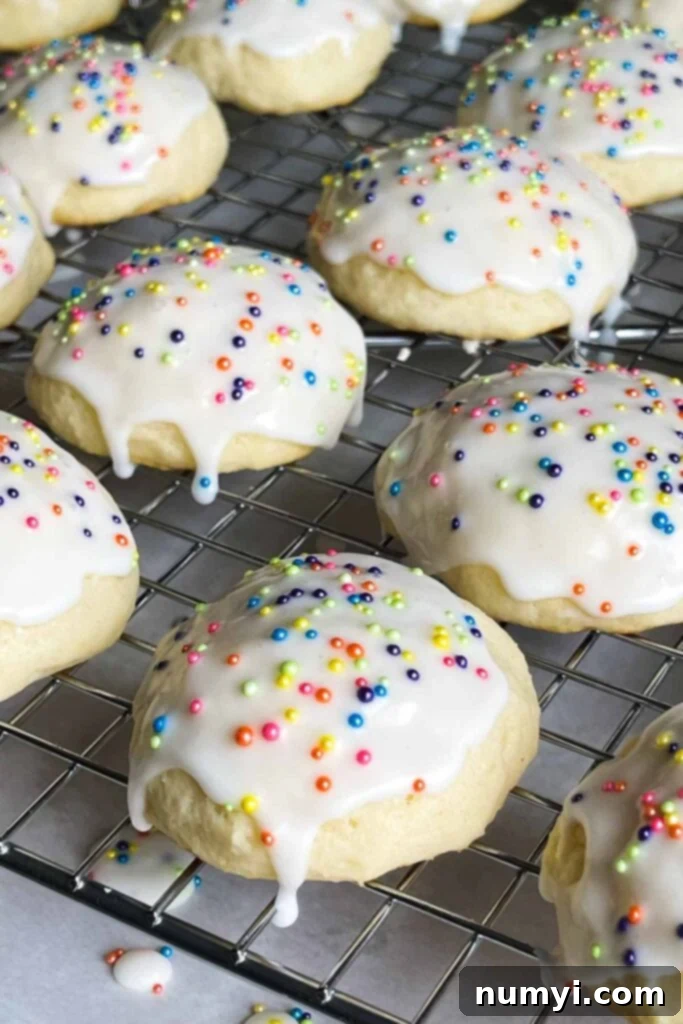 Close-up of a batch of fresh Italian ricotta cookies with white glaze and colorful sprinkles