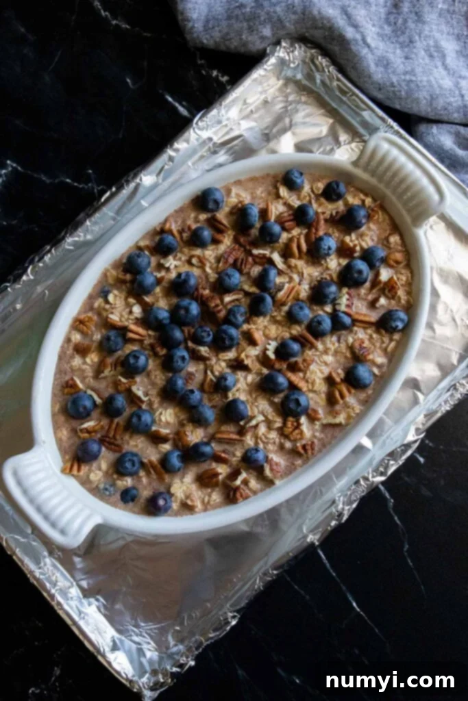 Unbaked blueberry oatmeal on a foil lined baking sheet.