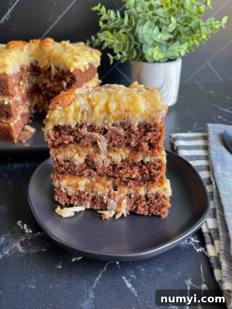 A mouthwatering slice of original Baker's German chocolate cake on a black plate, showing off its layered perfection with rich frosting.