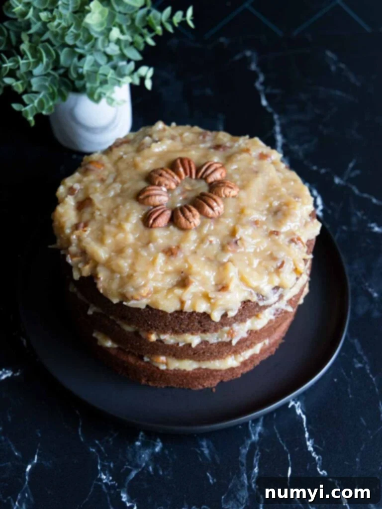 A beautifully presented whole Baker's German Chocolate Cake on a black plate, showcasing its rich chocolate layers and generous coconut pecan frosting.