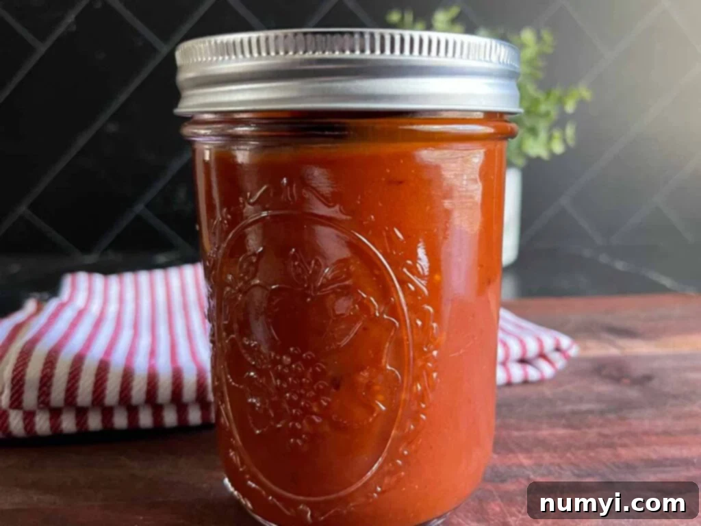 Smoky Bourbon Chipotle BBQ Sauce 2 Homemade bourbon chipotle barbeque sauce in a mason jar, showcasing its rich color and texture.