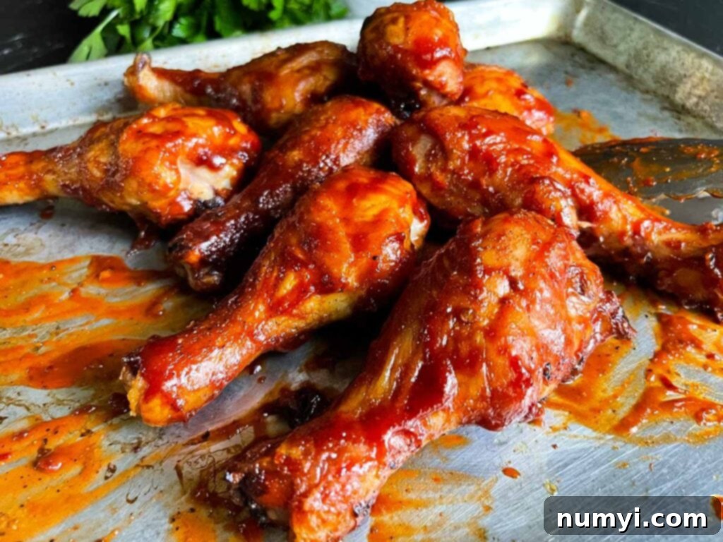 Bbq chicken legs on a baking sheet, ready to be seasoned.
