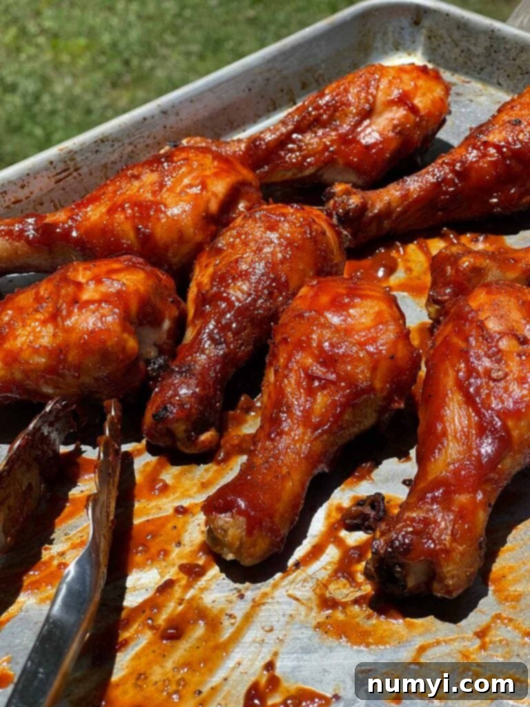 Perfectly cooked BBQ chicken legs, glistening with sauce, just off the grill.