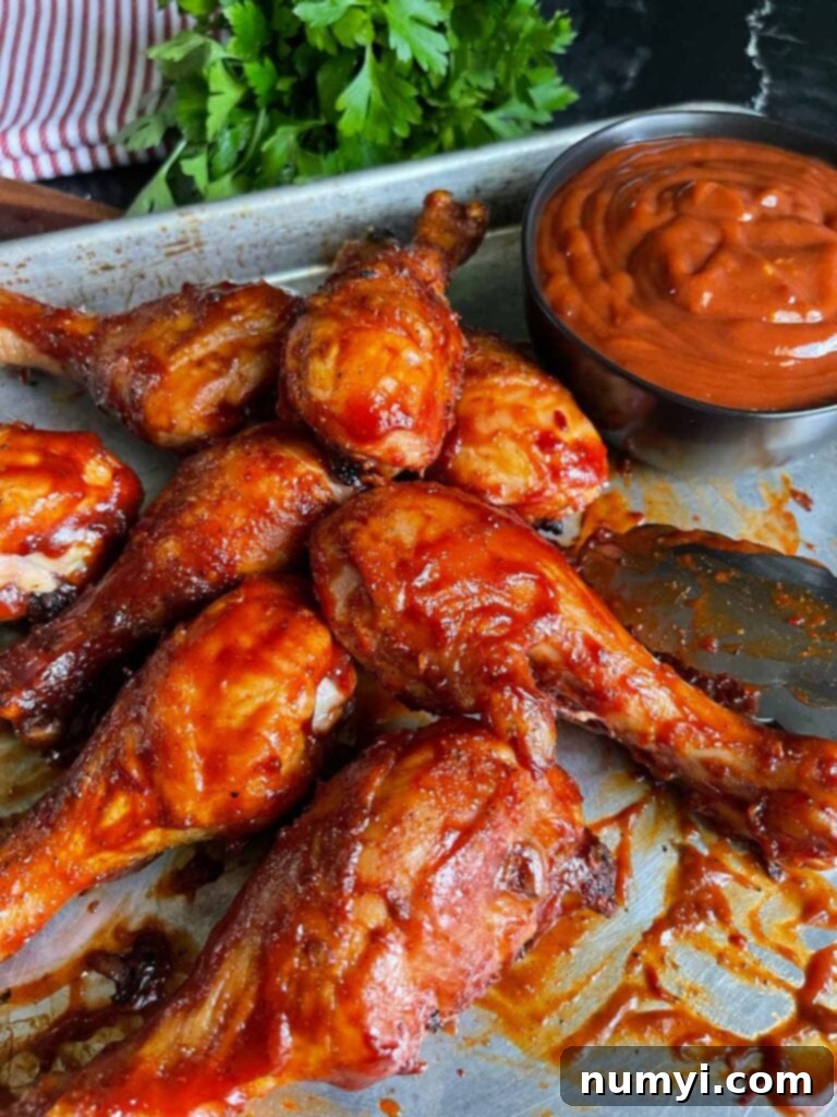 Arrangement of BBQ chicken legs on a sheet pan, ready for serving.