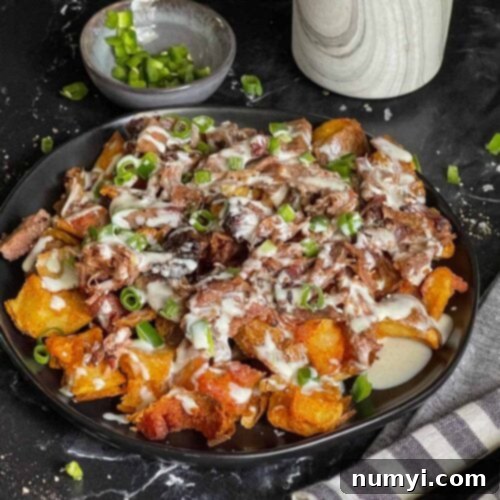 Loaded potato bites on a black plate.