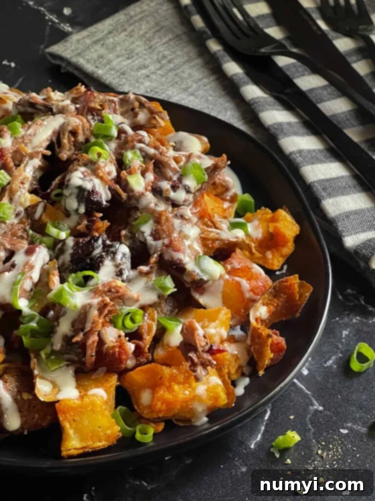 Close-up of a single loaded potato bite, highlighting the crispy potato, succulent brisket, and melted queso textures.