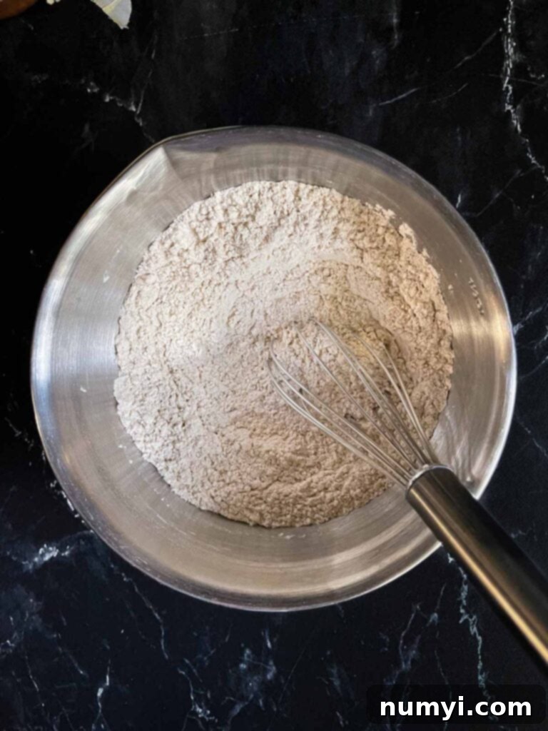 Combined dry ingredients for pumpkin bread in a mixing bowl.