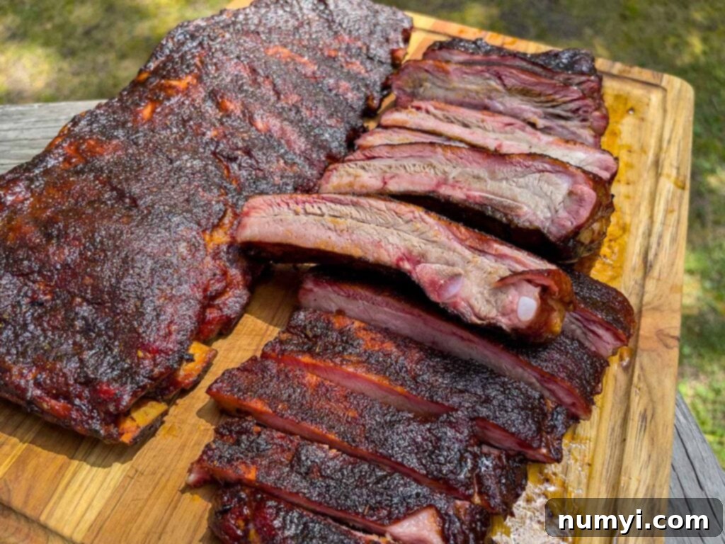 Two racks of perfectly smoked St. Louis style ribs on a cutting board, ready to be served.