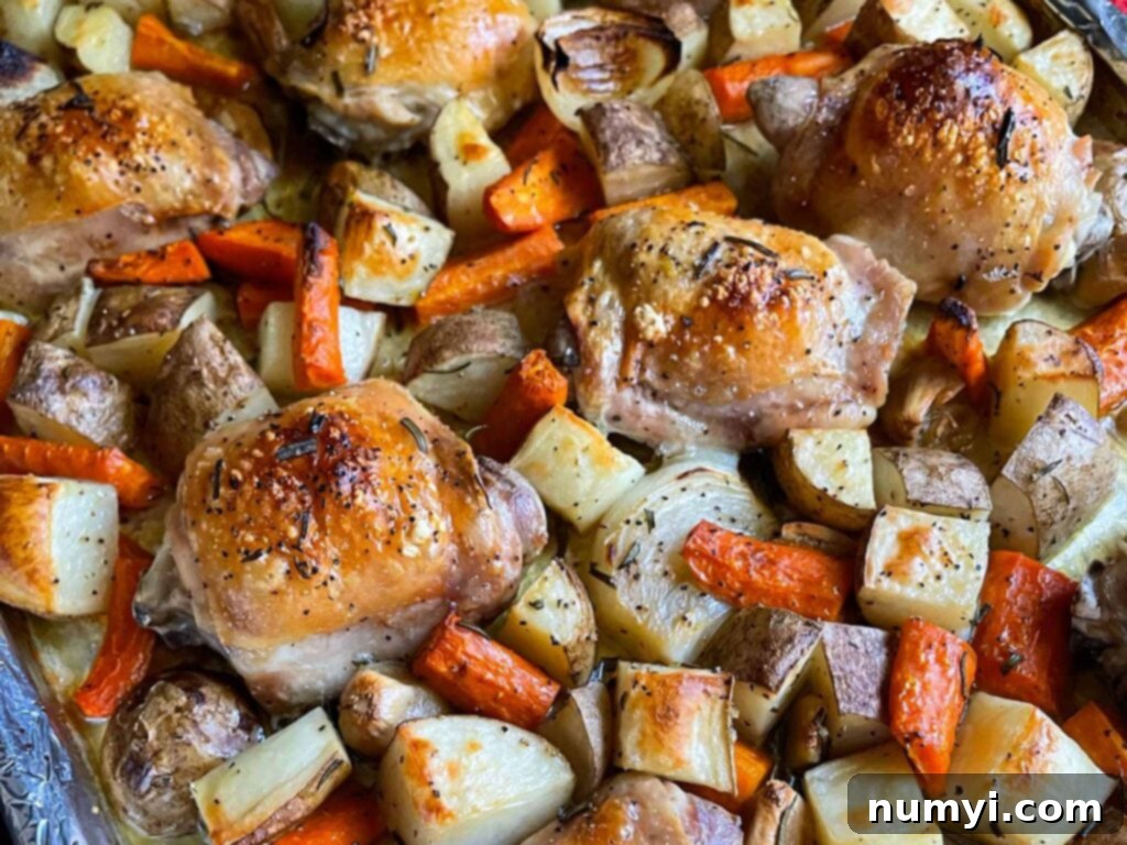 One-Pan Wonder: Roasted Chicken and Vegetables 2 One pan roasted chicken and vegetables in a foil and parchment paper lined baking sheet.