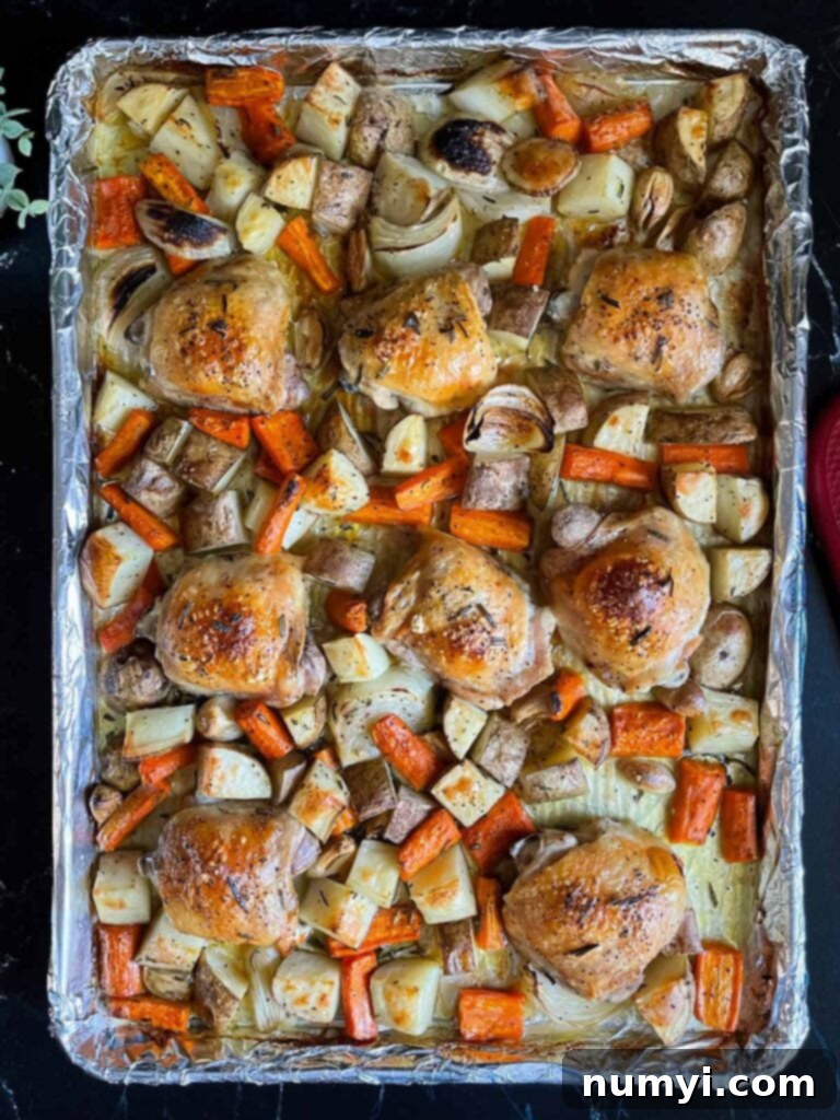 One-Pan Wonder: Roasted Chicken and Vegetables 7 One pan roasted chicken and vegetables in a foil and parchment paper lined baking sheet.