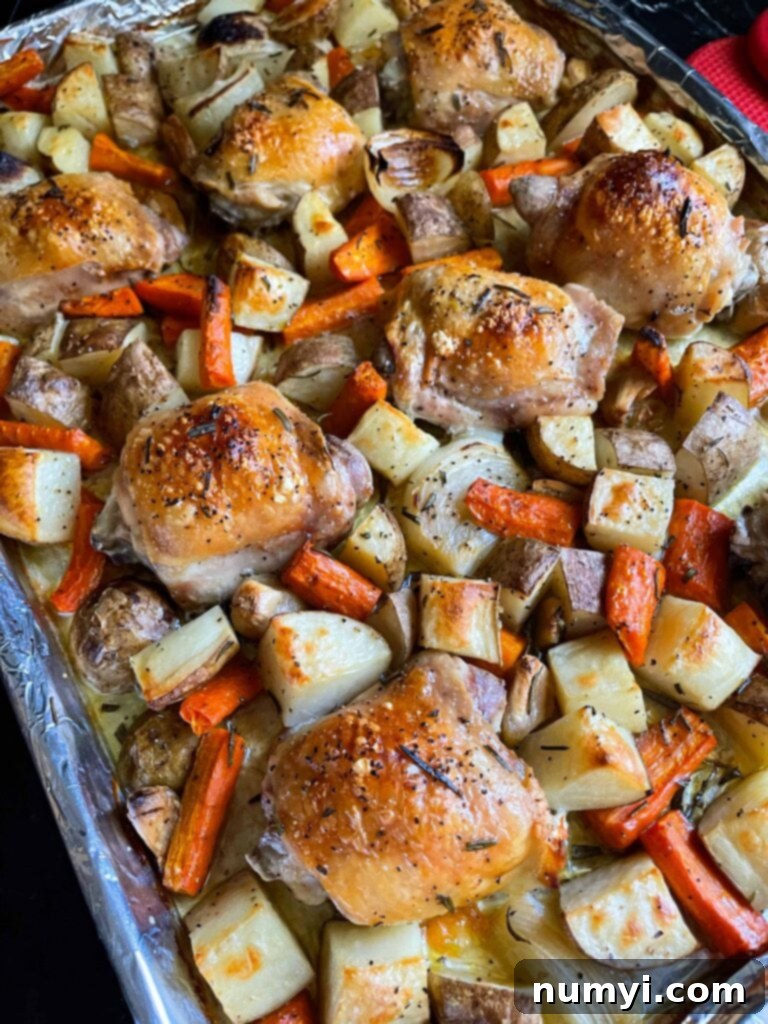 One-Pan Wonder: Roasted Chicken and Vegetables 8 One pan roasted chicken and vegetables in a foil and parchment paper lined baking sheet.