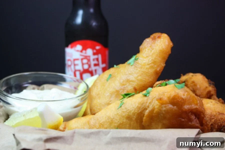Golden Ale-Battered Perfection 3 Crispy Beer Battered Fish in a basket with a beer in the background.