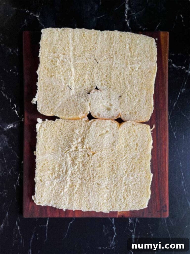 A package of Hawaiian sweet rolls cut in half horizontally, ready for assembly in a baking dish.