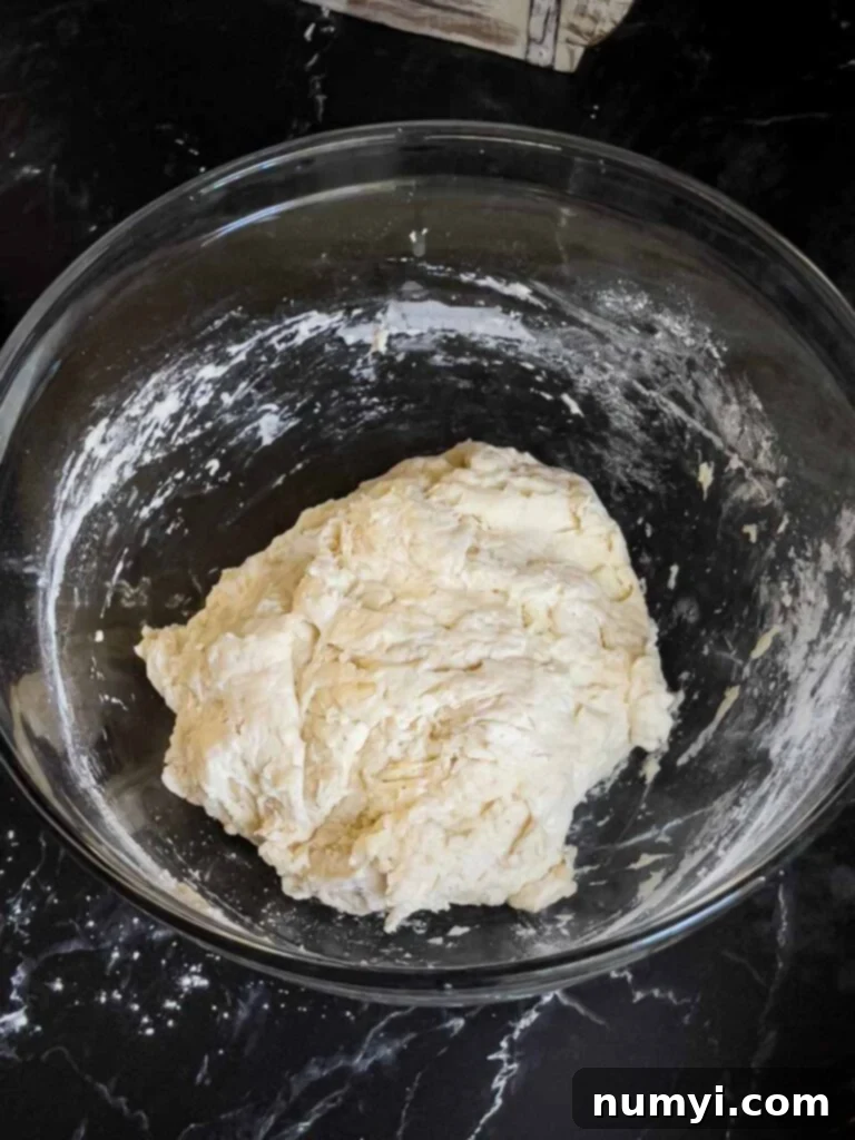 Focaccia dough just mixed together in a glass bowl.