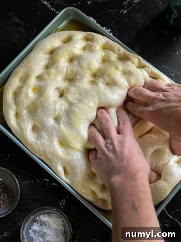Adding dimples to the focaccia dough.