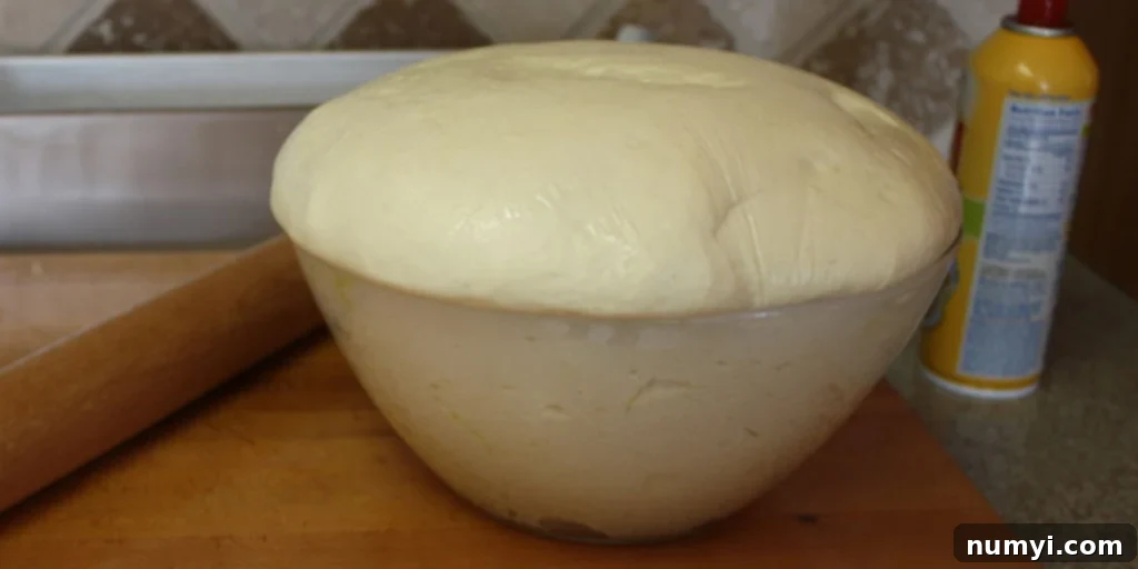 Bake Perfect Homemade Sandwich Bread 7 Bread dough dramatically risen over the sides of the glass bowl, showing successful bulk fermentation.