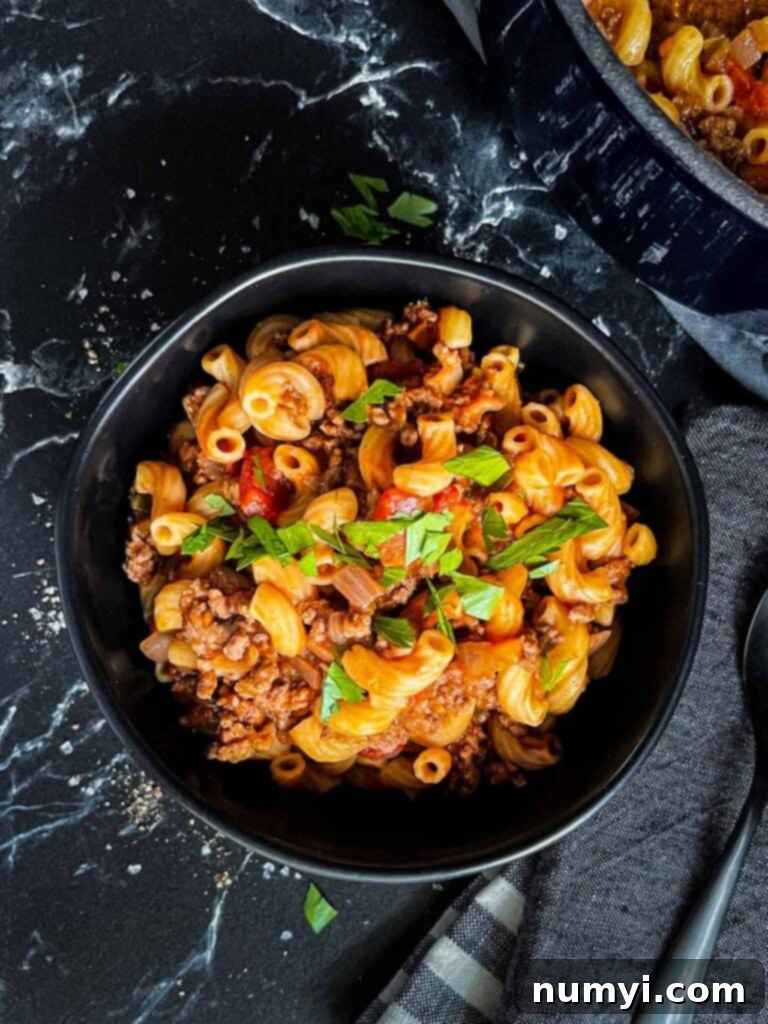Grandma's American Goulash 2 A bowl of goulash in a dark bowl.