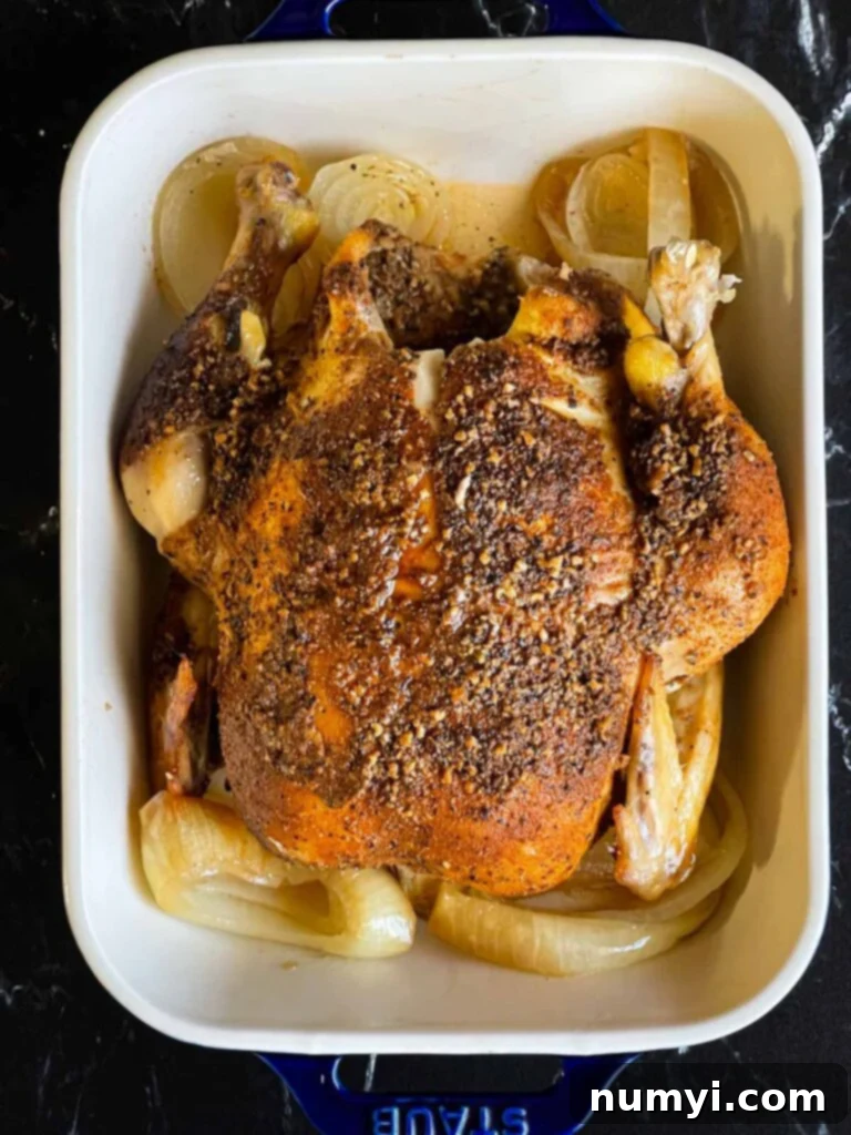 Perfectly Tender Slow Cooker Roasted Chicken 7 A whole slow cooker roasted chicken, perfectly cooked and tender, presented in a serving dish.