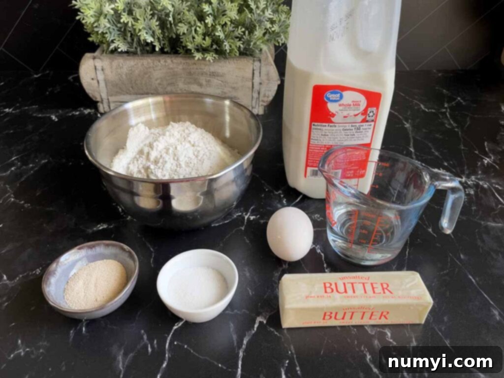 All the fresh ingredients for homemade crescent rolls laid out on a black surface.