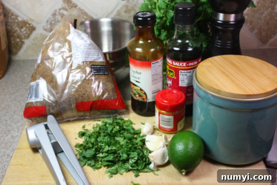 Golden Spice Chicken Skewers 3 Ingredients for the Turmeric Chicken Kabobs laid out on a wooden cutting board, including fresh cilantro, garlic, lime, and various sauces and spices.