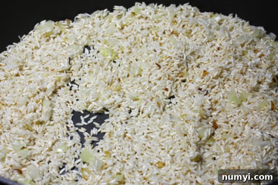 Your Favorite Restaurant Style Mexican Rice At Home 3 Rice browning in large skillet with sauteed onions