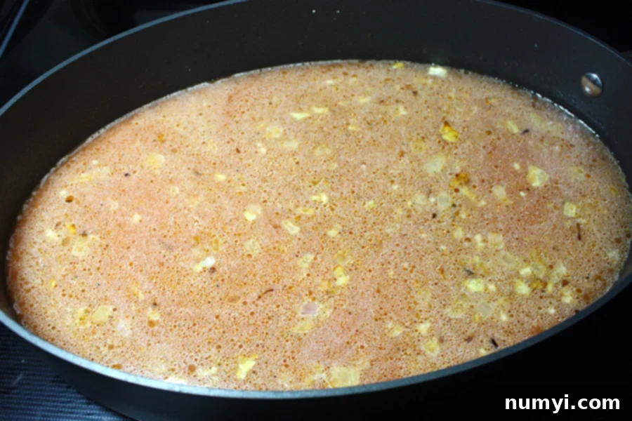 Your Favorite Restaurant Style Mexican Rice At Home 4 Mexican Rice stock and spices added to skillet