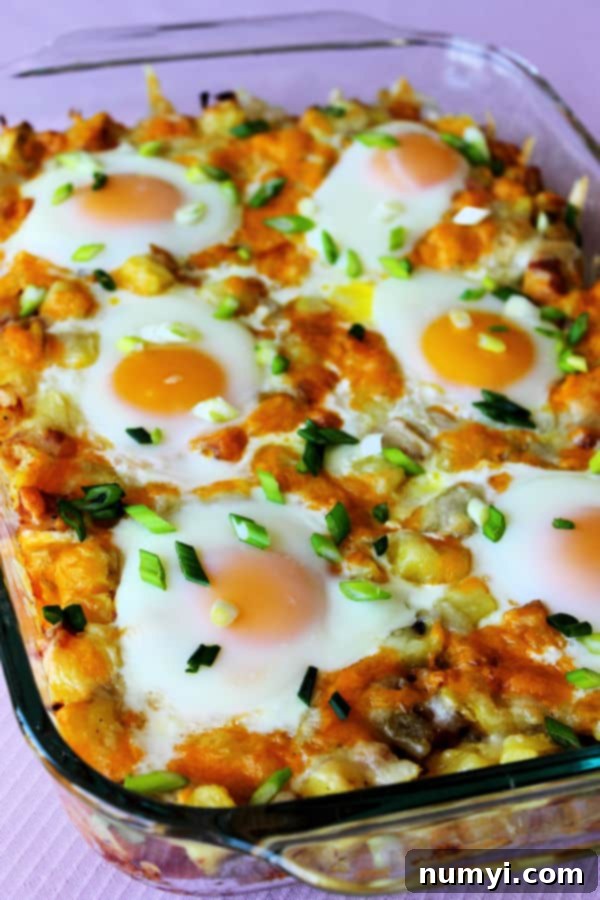Close-up of Ham and Potato Breakfast Bake with melted cheese and fresh eggs