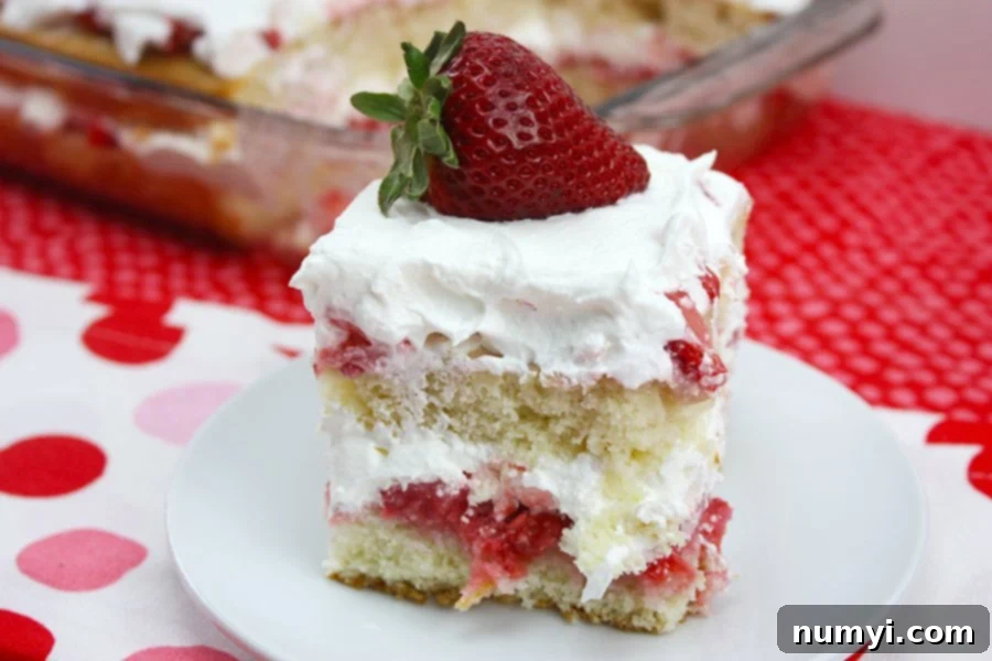 Homemade Strawberry Shortcake Perfection 2 Homemade strawberry shortcake with a fresh strawberry on a white plate, showcasing its fluffy cake, vibrant strawberries, and creamy whipped topping.