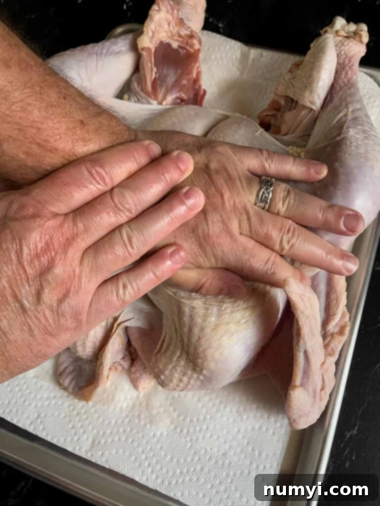 The Ultimate Dry Brined Spatchcock Turkey 9 Breaking the breastbone of a turkey using the heels of the palm.