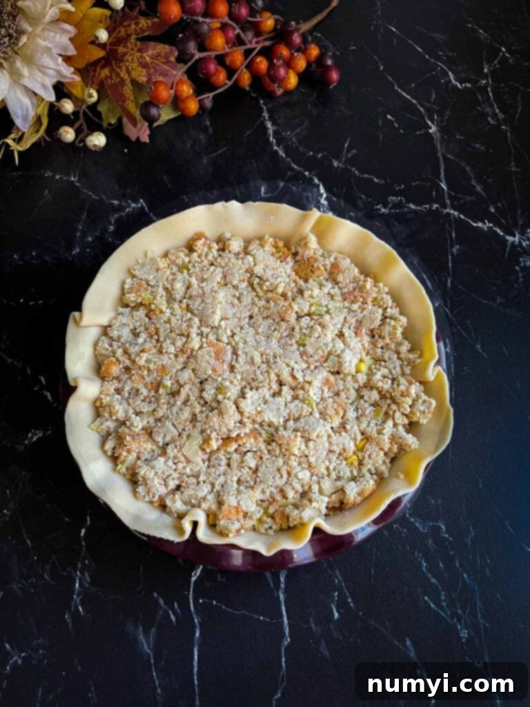 Thanksgiving Encore Pie 8 Multiple layers of Thanksgiving leftovers, including turkey, mashed potatoes, corn, and dressing, visibly stacked within a pie crust.