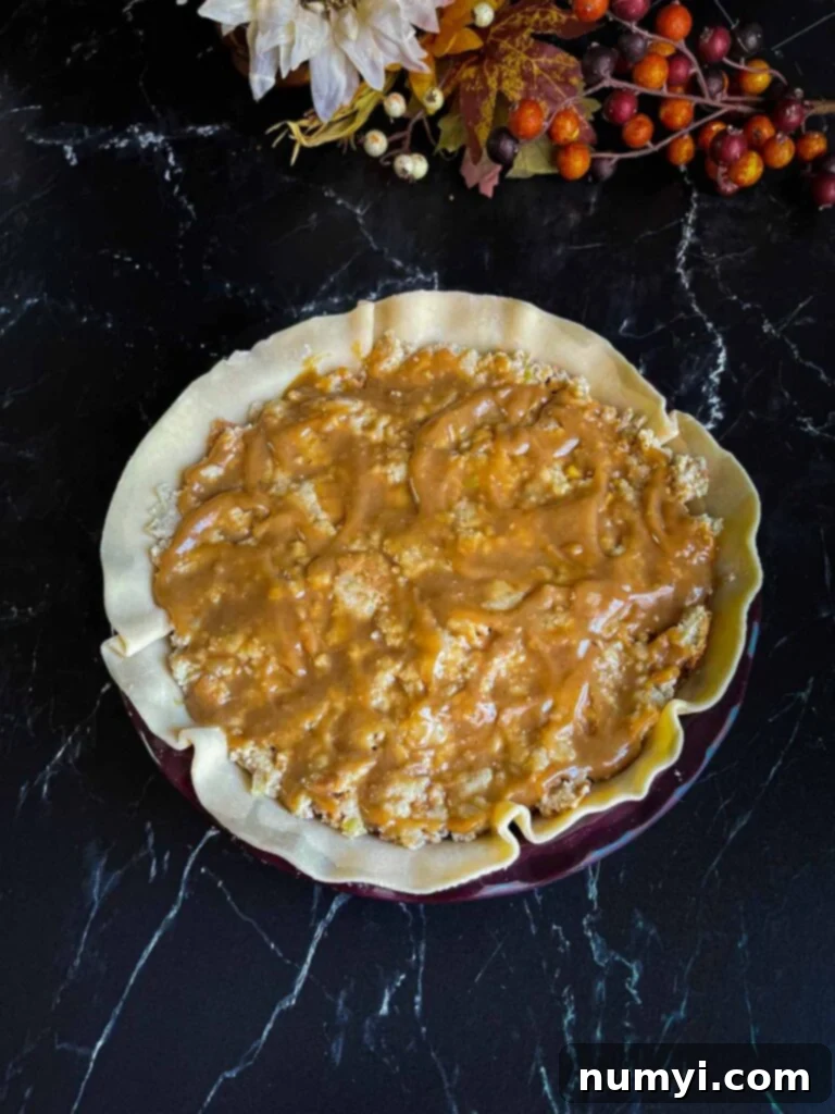 Thanksgiving Encore Pie 9 Rich brown gravy being poured over the top layer of cornbread dressing in a Thanksgiving leftover pie.