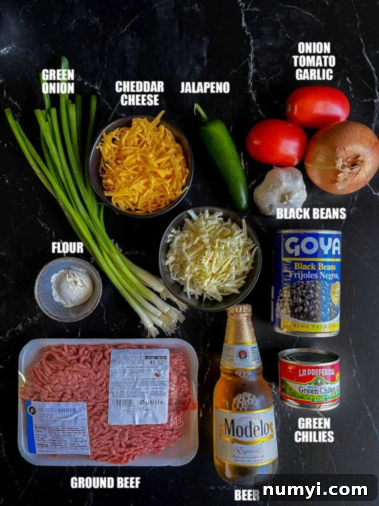 Molten Beef & Cheese Dip 4 A vibrant selection of fresh ingredients laid out, including cheese, ground beef, onion, garlic, and chilies, all prepped for making Queso Fundido.