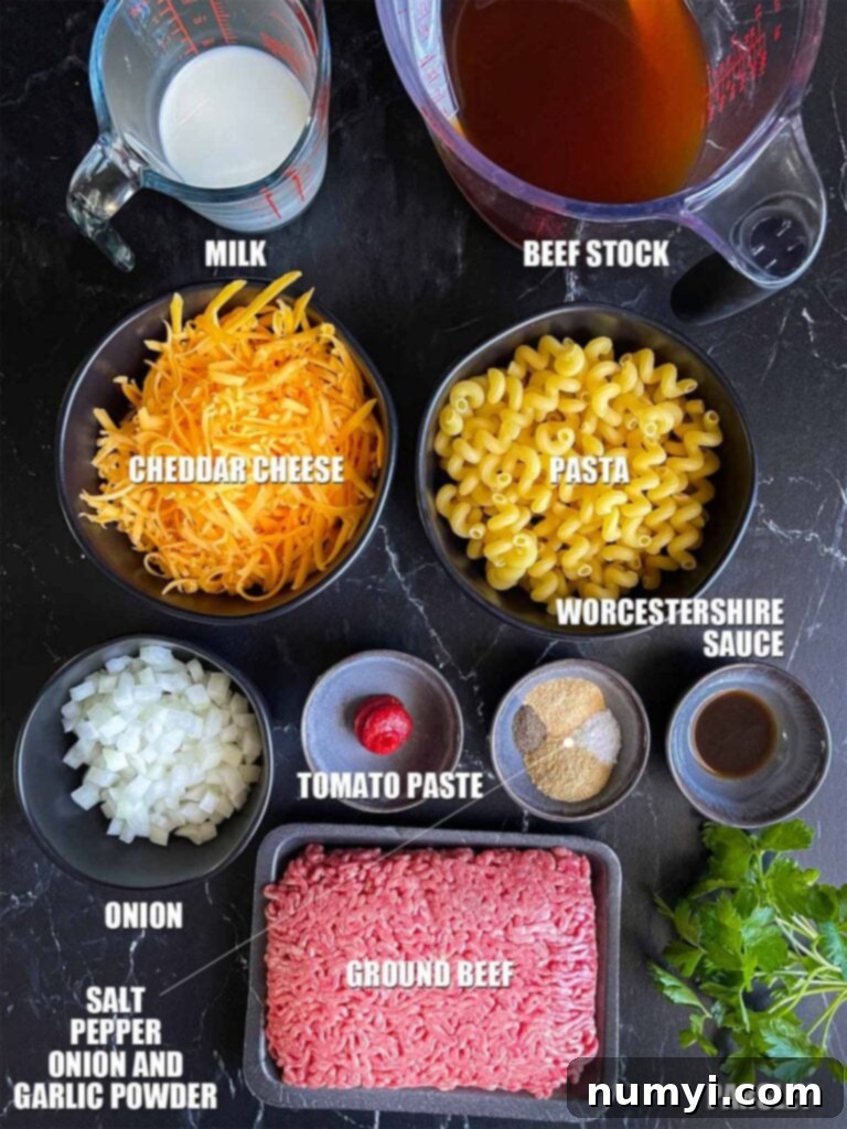 A flat lay of fresh ingredients for homemade one-pot Hamburger Helper, including ground beef, pasta, cheese, and various seasonings.