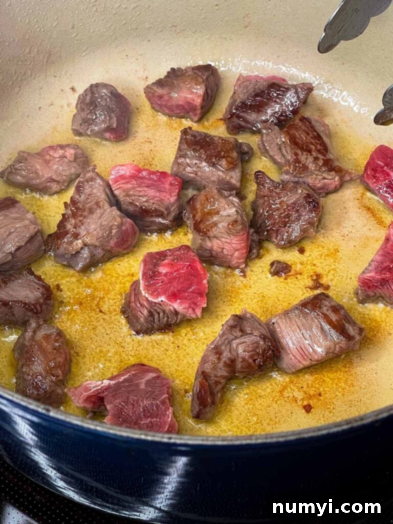 Stew meat browning in a dutch oven.