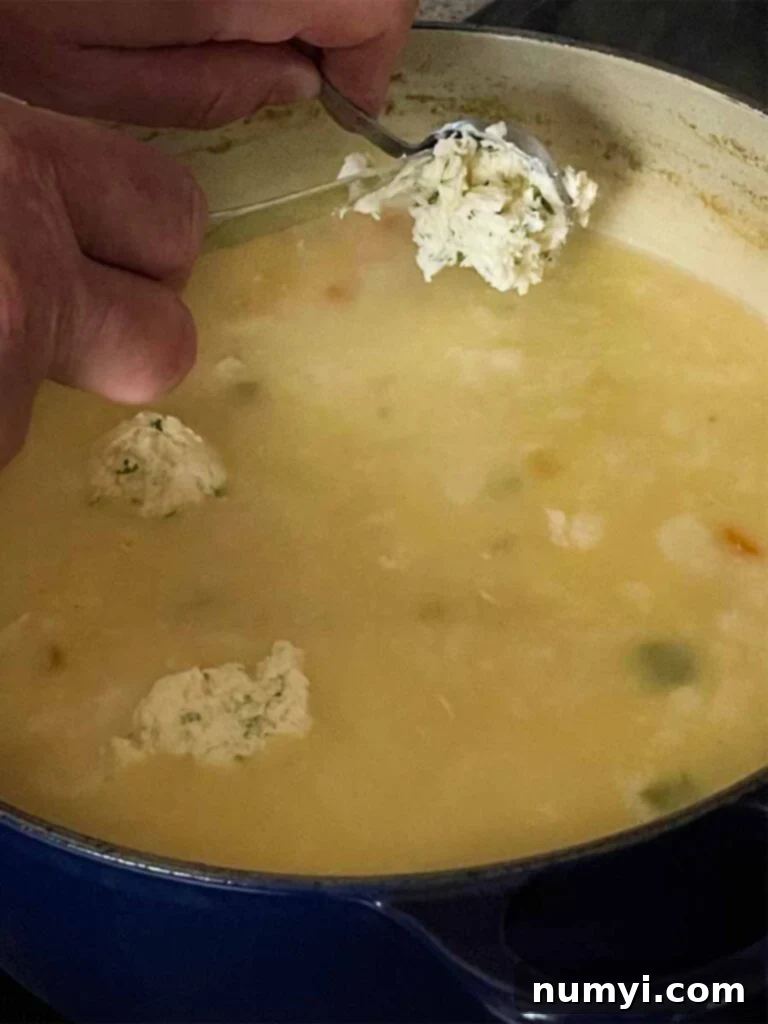 Dropping dumpling dough into the chicken soup.