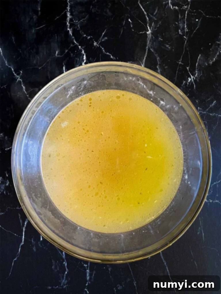 Homemade chicken stock in a glass bowl.