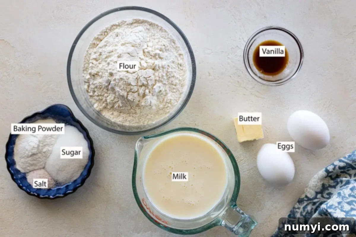 Effortless Fluffy Homemade Pancakes 2 A flat lay of all the simple ingredients required for homemade pancakes: all-purpose flour, milk, eggs, butter, vanilla extract, baking powder, salt, and granulated sugar.