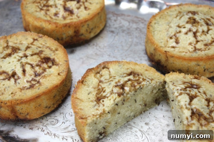 Instant Delight: Seed Cake for Spontaneous Gatherings 2 Golden brown seed cakes arranged beautifully on a silver serving platter, ready to be enjoyed.