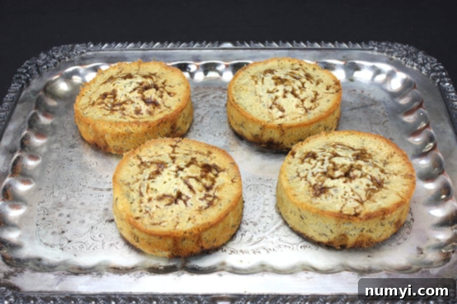 Instant Delight: Seed Cake for Spontaneous Gatherings 6 Elegant presentation of baked seed cakes on a silver serving platter, showcasing their golden crust.