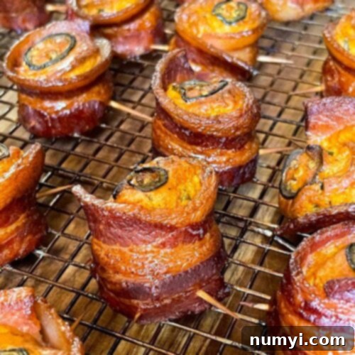Smoked Bacon Sausage Bites 16 Smoked pig shots with crispy bacon and melted cheese filling on a cooling rack.