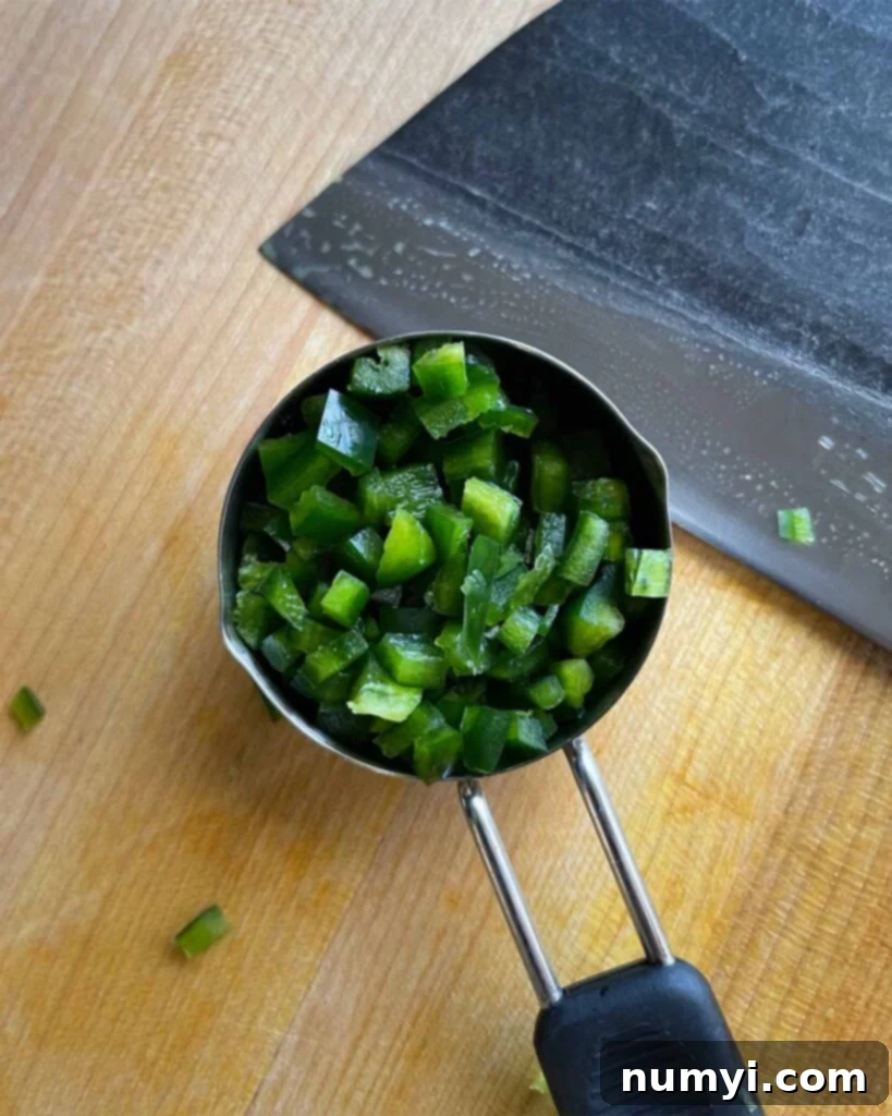 Smoked Bacon Sausage Bites 4 Halved and deseeded fresh jalapeño peppers on a cutting board, ready for dicing.