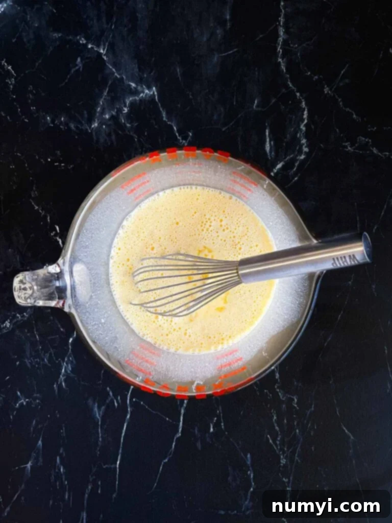The Ultimate Chile Relleno Casserole 11 Seasoned egg mixture in a mixing bowl.