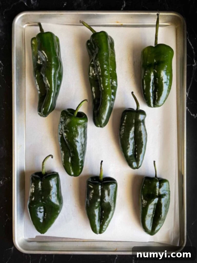 The Ultimate Chile Relleno Casserole 5 Poblano peppers on a baking sheet.