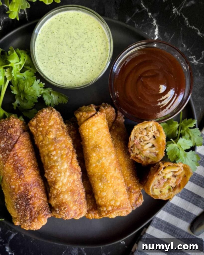 Redneck egg rolls on a dark plate with dipping sauces.