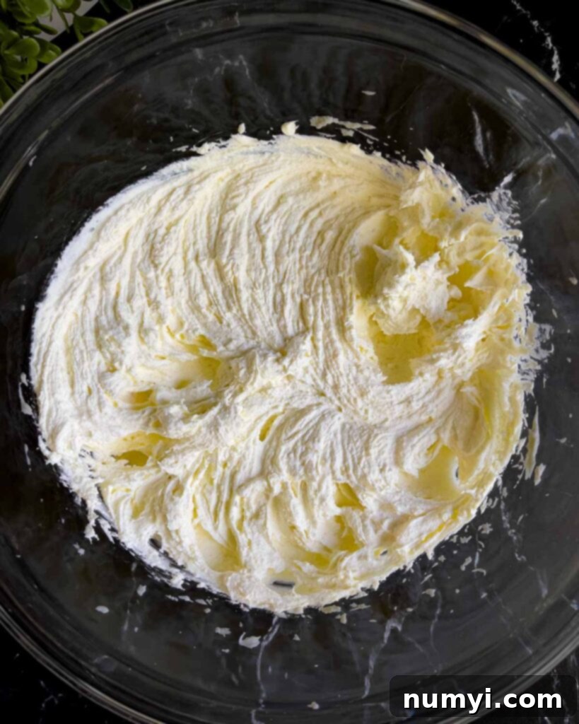 Smooth, creamy ricotta and mascarpone cheese mixture in a glass mixing bowl, after being beaten together.