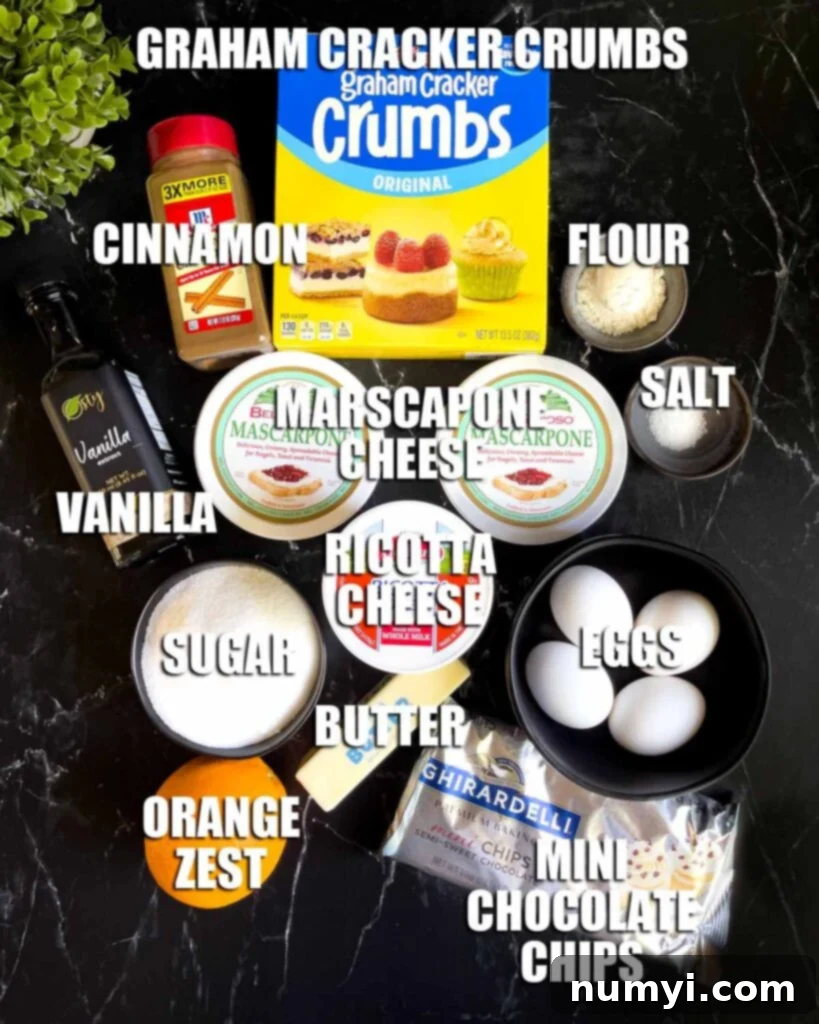 All the fresh ingredients for cannoli cheesecake laid out on a dark background, including blocks of cheese, eggs, chocolate chips, and spices.