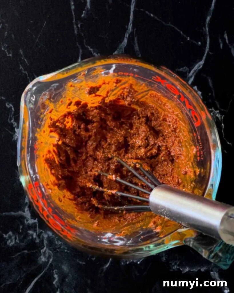 A vibrant, thick marinade for Mexican grilled chicken breast (Pechuga Asada) in a bowl.