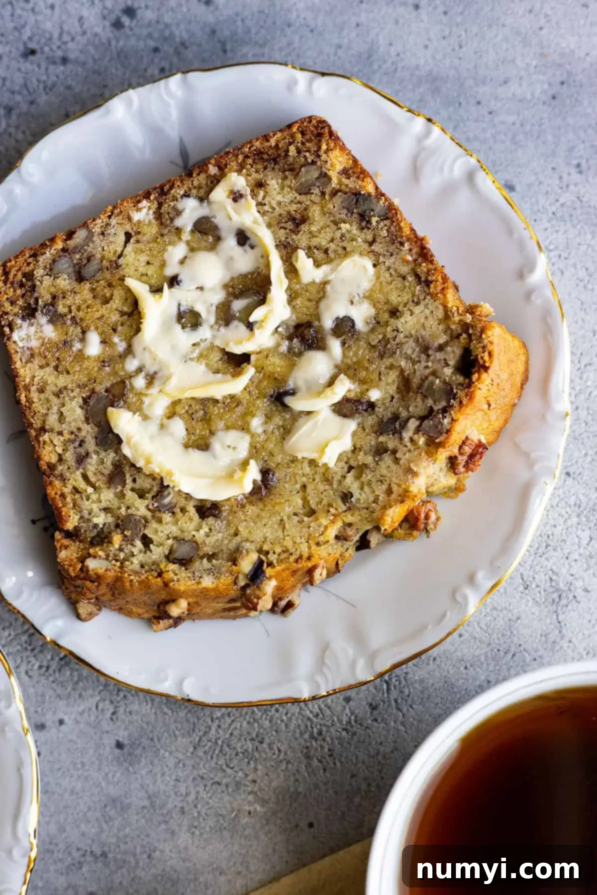 Ultimate Banana Nut Loaf 6 Overhead view of a slice of bread with butter melting on it.